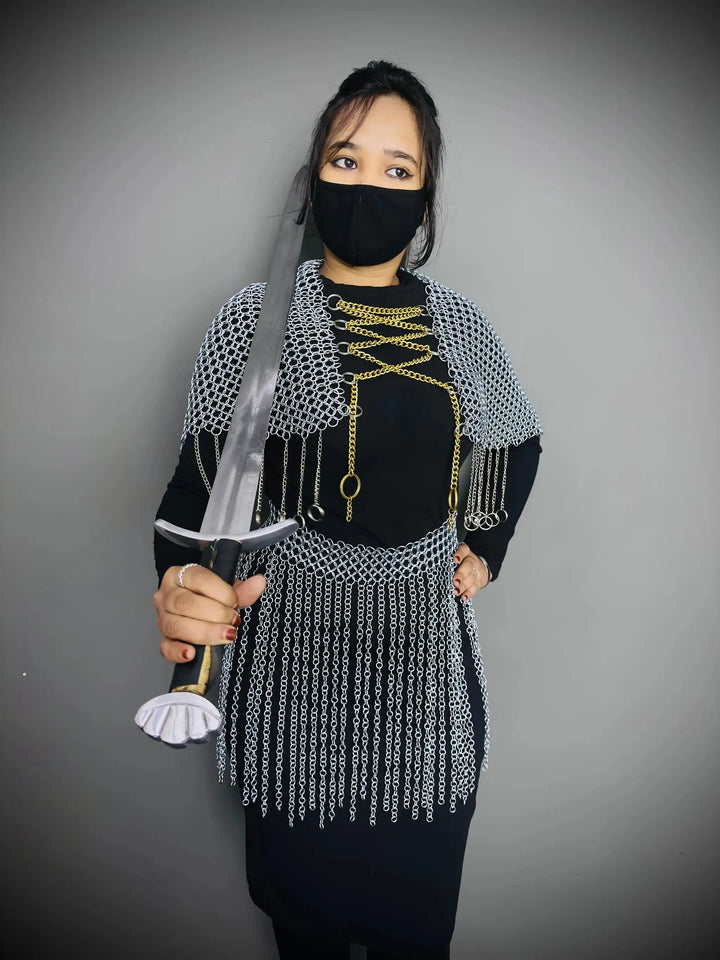 Person wearing chainmail and holding a sword against a gray background