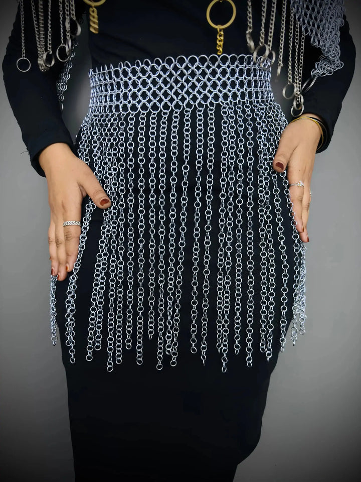 Person wearing a chainmail skirt with a plain background
